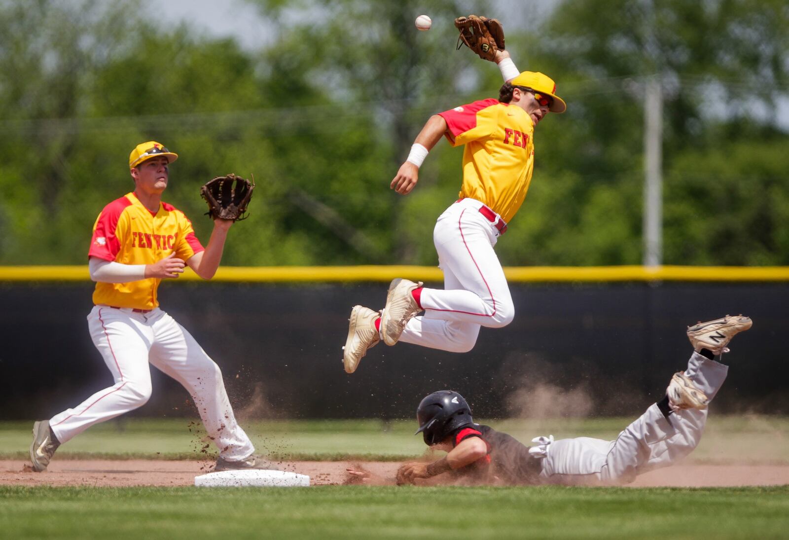 Franklin’s Aiden Kinser slides safely into second base as Fenwick’s Alex Abbott (right) and Thomas Vogelsang try to catch the ball during Friday’s Division II district baseball final at Miamisburg’s Toadvine Field. Franklin won 11-2. NICKGRAHAM/STAFF