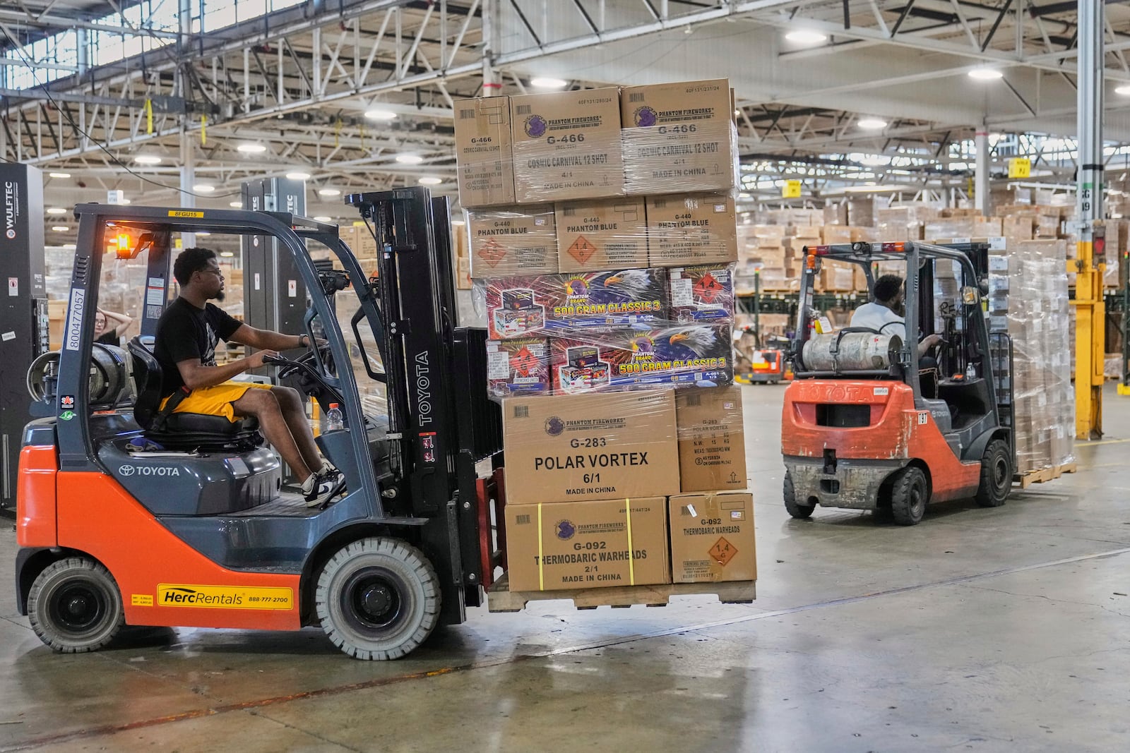 A worker uses a forklift to move fireworks in preparation for shipping, at the Phantom Fireworks warehouse in Warren, Ohio Wednesday, June 25, 2025. (AP Photo/Sue Ogrocki)