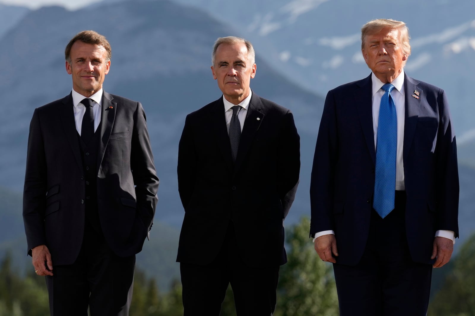From left, France's President Emmanuel Macron, Canada's Prime Minister Mark Carney and President Donald Trump, pose during a group photo at the G7 Summit, Monday, June 16, 2025, in Kananaskis, Canada. (AP Photo/Mark Schiefelbein)