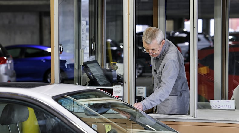 Kevin Johnston works the exit gate at the Butler County Government Services Center parking garage Thursday, Jan. 6, 2022 in Hamilton. Butler County Commissioners have awarded a $200,000 contract to fully automate the garage. NICK GRAHAM / STAFF