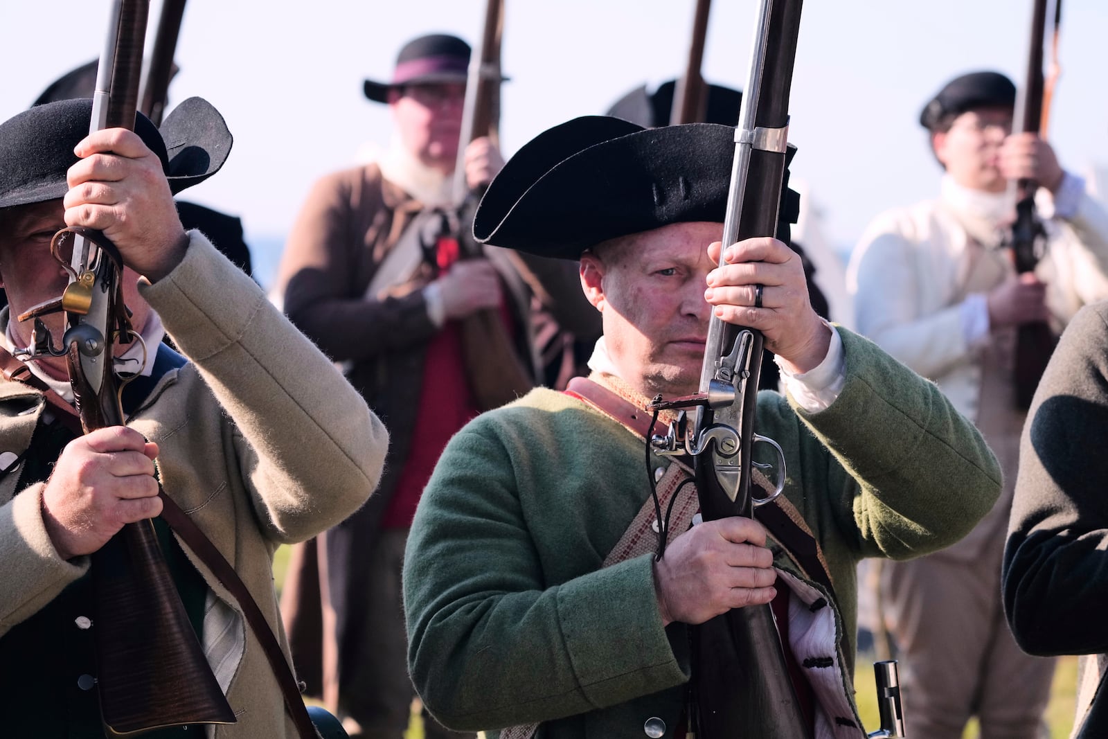 Chris Silver, right, of Celina, Ohio, prepares to face the British during a reenactment in celebration of the 250th anniversary of the Battle of Bunker Hill, Saturday, June 21, 2025, in Gloucester, Mass. (AP Photo/Charles Krupa)