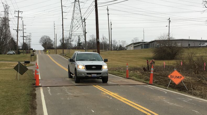 A vehicle slows going over road plates that have been placed in the 600-block of Todhunter Road after a sanitary sewer line break was detected. Monroe officials said the road sank about three inches which required the installing the road plates. Butler County Water and Sewer Department is working to repair the sanitary sewer line. ED RICHTER/STAFF