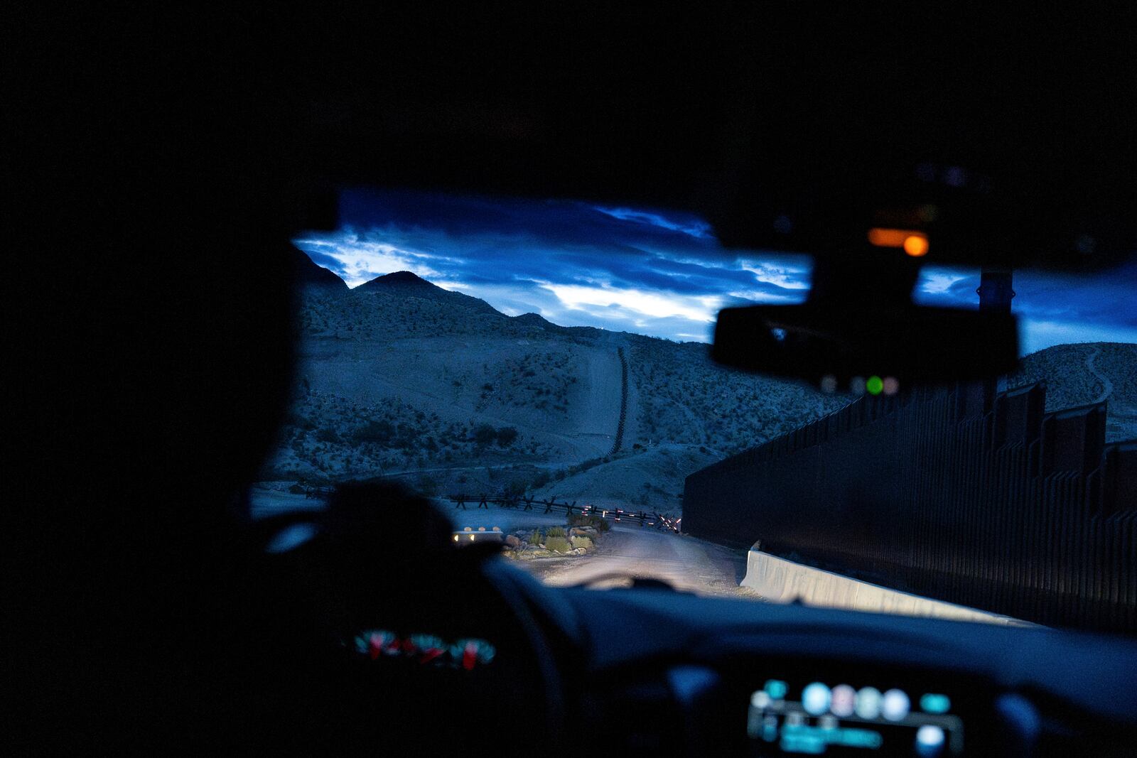 A view from inside a U.S. Border Patrol vehicle shows the U.S.-Mexico border fence at dawn in Sunland Park, N.M., Wednesday, July 23, 2025. (AP Photo/Jae C. Hong)