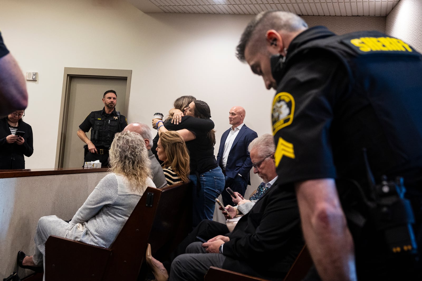 Supporters of former Grand Rapids Police officer Christopher Schurr hug after Judge Christina Mims declared a mistrial at the Kent County Courthouse in Grand Rapids, Mich., Thursday, May 8, 2025. (Joel Bissell/MLive.com/Kalamazoo Gazette via AP)