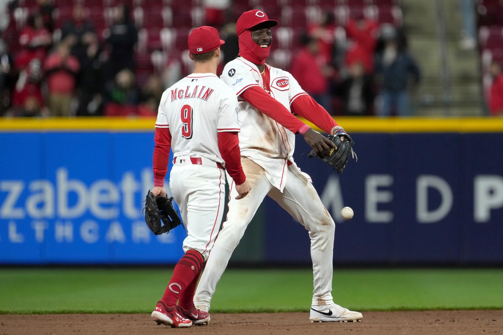 Cincinnati Reds' Matt McLain, left, and Elly De La Cruz, right, celebrate after a win in a baseball game against the Texas Rangers, Monday, March 31, 2025, in Cincinnati. (AP Photo/Kareem Elgazzar)