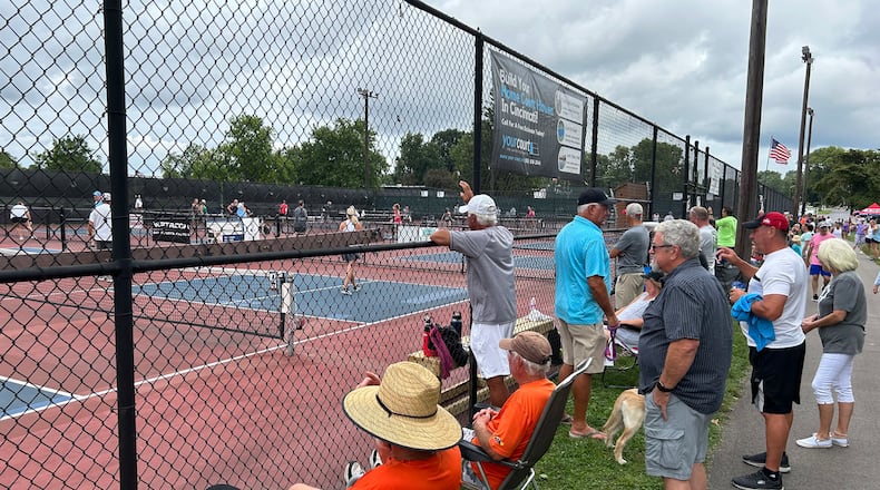 Fans line the fence to watch the action Sunday morning during the 16th annual Middletown Pickleball Association Tournament at Lefferson Park. The tournament, for those 50 and older, attracted 400 players from seven states, said Michell Cook, tournament director. RICK McCRABB/STAFF