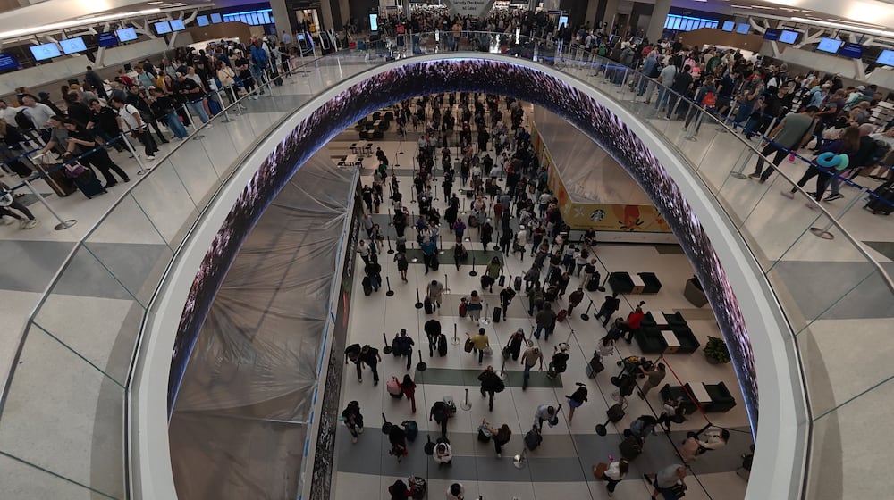 Travelers line up at a TSA checkpoint at George Bush Intercontinental Airport in Houston, Thursday, March 26, 2026. (AP Photo/Lekan Oyekanmi)