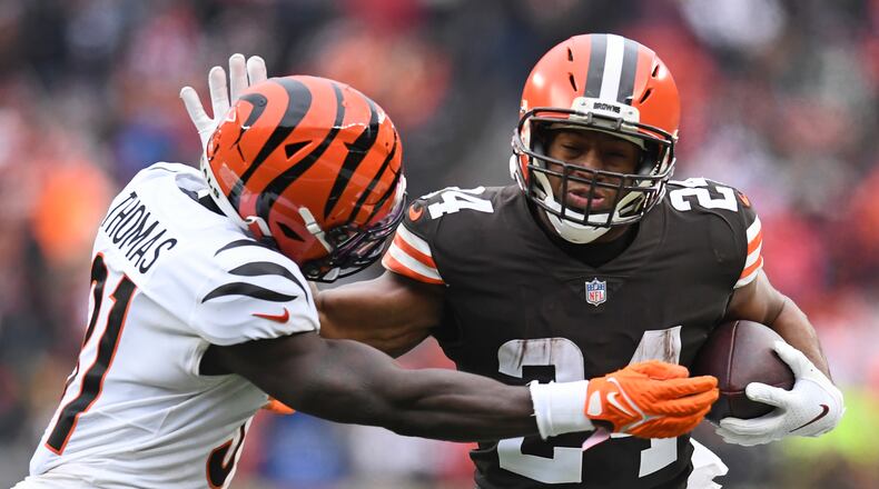 Cleveland Browns running back Nick Chubb (24) tries to break a tackle from Cincinnati Bengals defensive back Michael Thomas (31) during the second half of an NFL football game, Sunday, Jan. 9, 2022, in Cleveland. (AP Photo/Nick Cammett)