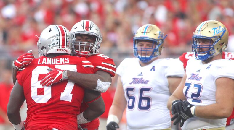 Ohio State’s Tyquan Lewis hugs Robert Landers (67) after a tackle against Tulsa on Saturday, Sept. 10, 2016, at Ohio Stadium in Columbus. David Jablonski/Staff