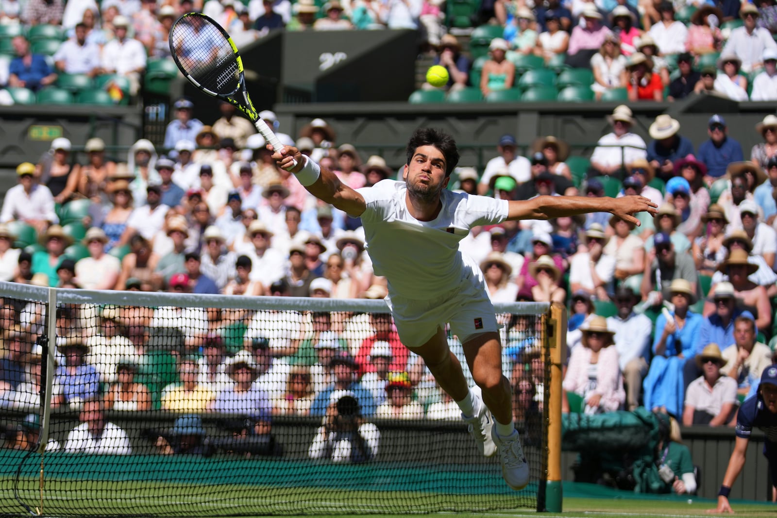 Carlos Alcaraz of Spain returns the ball to Taylor Fritz of the U.S. during the men's semifinal singles match at the Wimbledon Tennis Championships in London, Friday, July 11, 2025.(AP Photo/Joanna Chan)