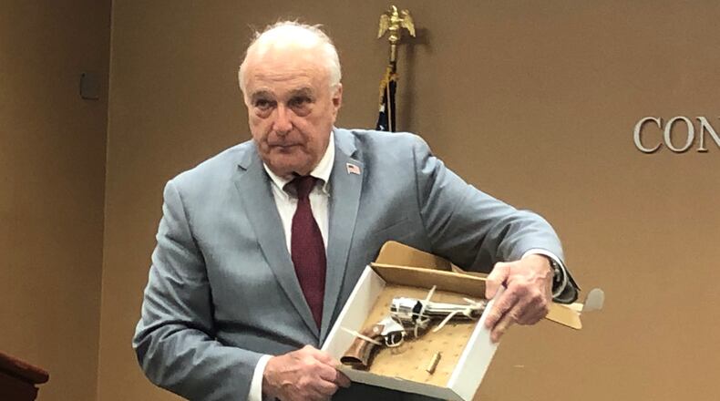 Butler Co. Prosecutor Michael Gmoser on April 5, 2022 shows members of the media a gun allegedly aimed at Monroe police by Dustin Booth in an incident Feb. 11 in which Booth was shot by police 13 times. When Booth pointed his weapon, Gmoser said, the officers had “no time” for crisis intervention, or psychiatric evaluation, or which officer should shoot first, or should the officers shoot at all. JOURNAL-NEWS