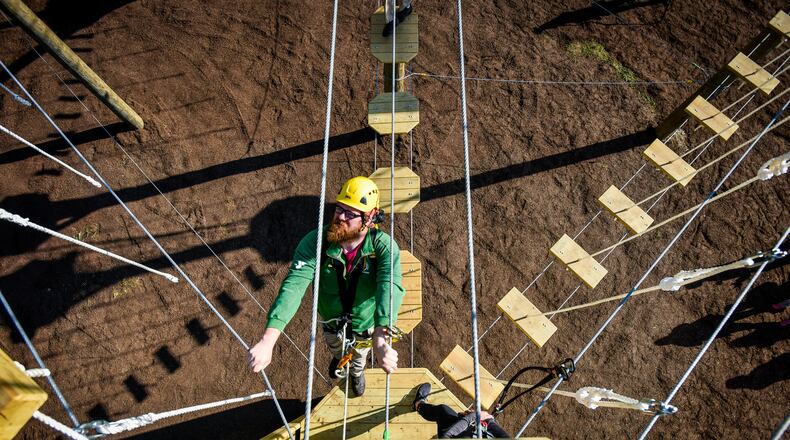 Sean Brown, senior director of Camp Campbell Gard outdoor education, observes climbers on the Great Miami Valley YMCA's high ropes course now open at Camp Campbell Gard on Wednesday, May 15, 2019, on Augspurger Road in St. Clair Township. The course stands nearly fifty feet tall with three levels of elements ranging in difficulty. There is also a climbing wall, zip line, giant swing and more. The course has a universal access system allowing participants with all abilities, including those in wheel chairs, the opportunity to experience it. NICK GRAHAM/STAFF