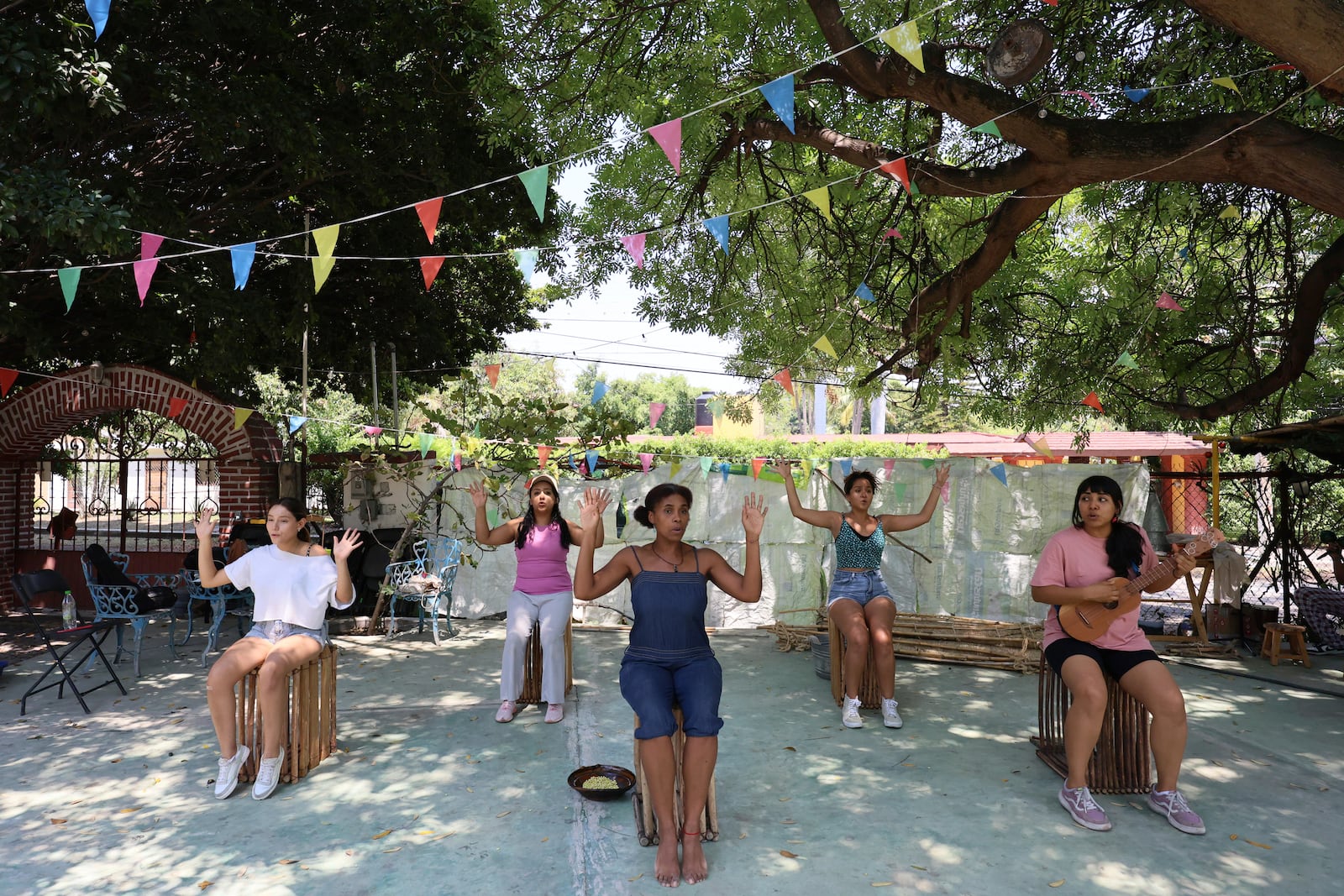 Mulato Teatro cast members from left to right, Azul Ruíz; Marlene Romero; Marisol Castillo; Caro Rodríguez and Eréndira Castorela strumming a jarana instrument, rehearse for their upcoming performance in the First International Afro-Scenic Festival, in Ticumán, Mexico, Saturday, May 17, 2025. (AP Photo/Ginnette Riquelme)