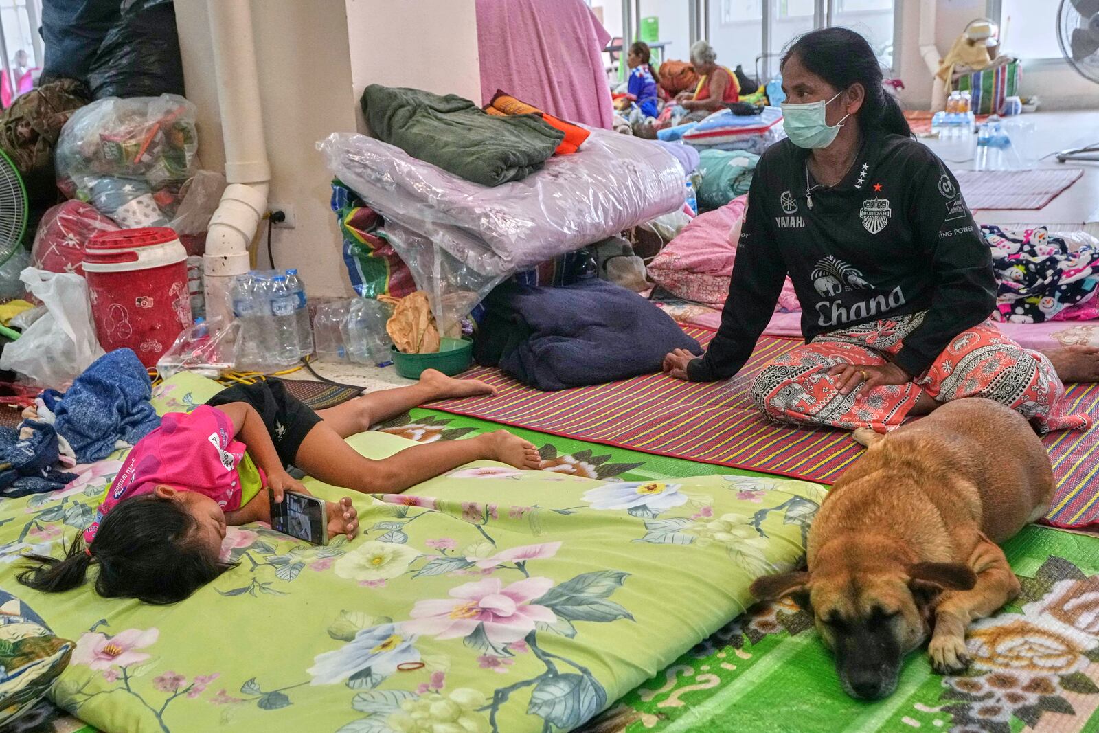 Thai residents who fled homes following the clashes between Thai and Cambodian soldiers, rest at an evacuation center in Surin province, Thailand, Wednesday, July 30, 2025. (AP Photo/Sakchai Lalit)