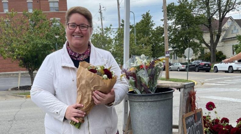 Laura Brubaker, of Little Creek Farm in West Manchester, holds a bunch of her flowers that she sells at the oxford Farmers Market. XINGRUI LU/OXFORD OBSERVER