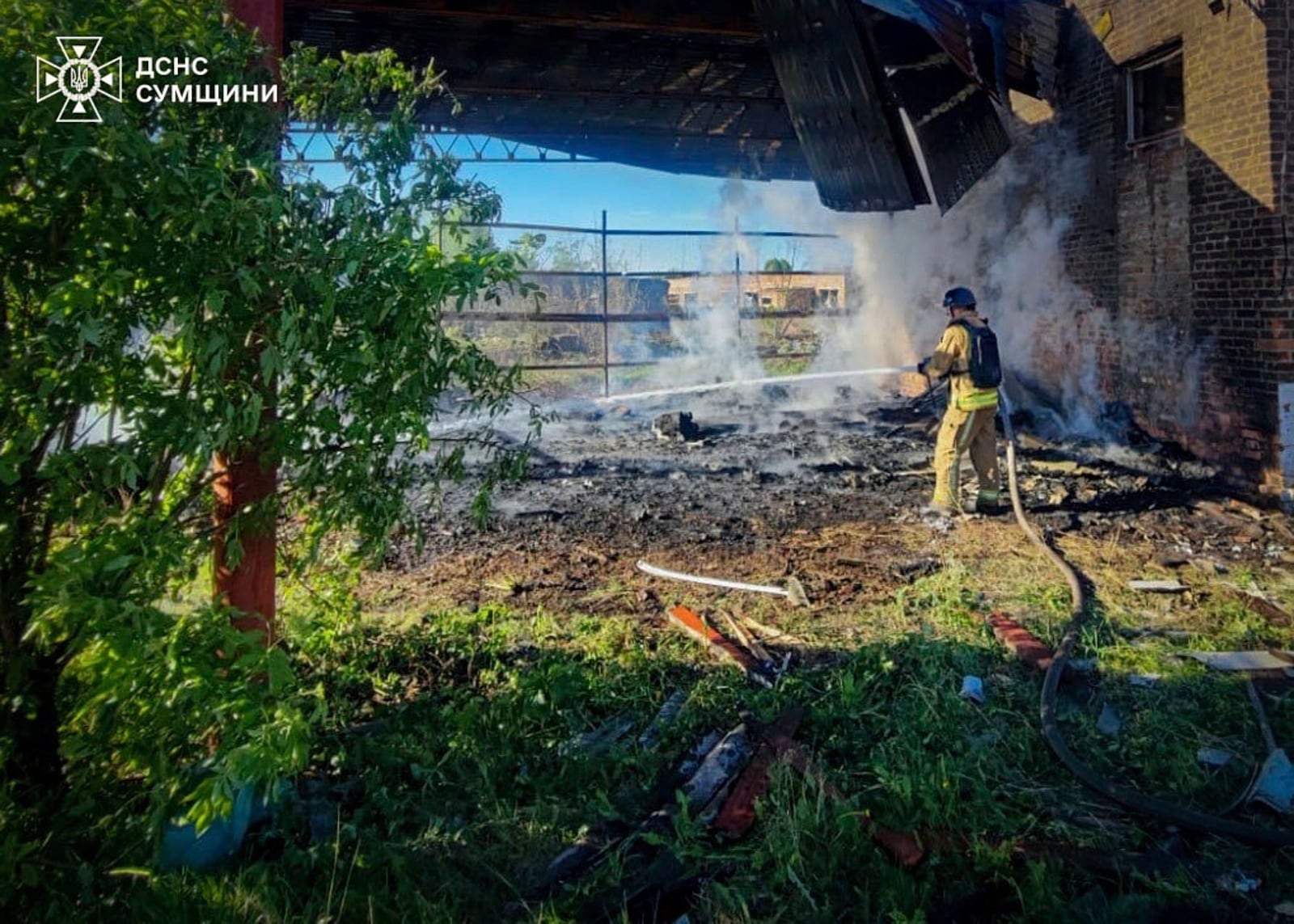 In this photo provided by the Ukrainian Emergency Services on May 8, 2025, a rescue worker puts out a fire of a building which was heavily damaged by a Russian strike in Sumy region, Ukraine. (Ukrainian Emergency Service via AP)