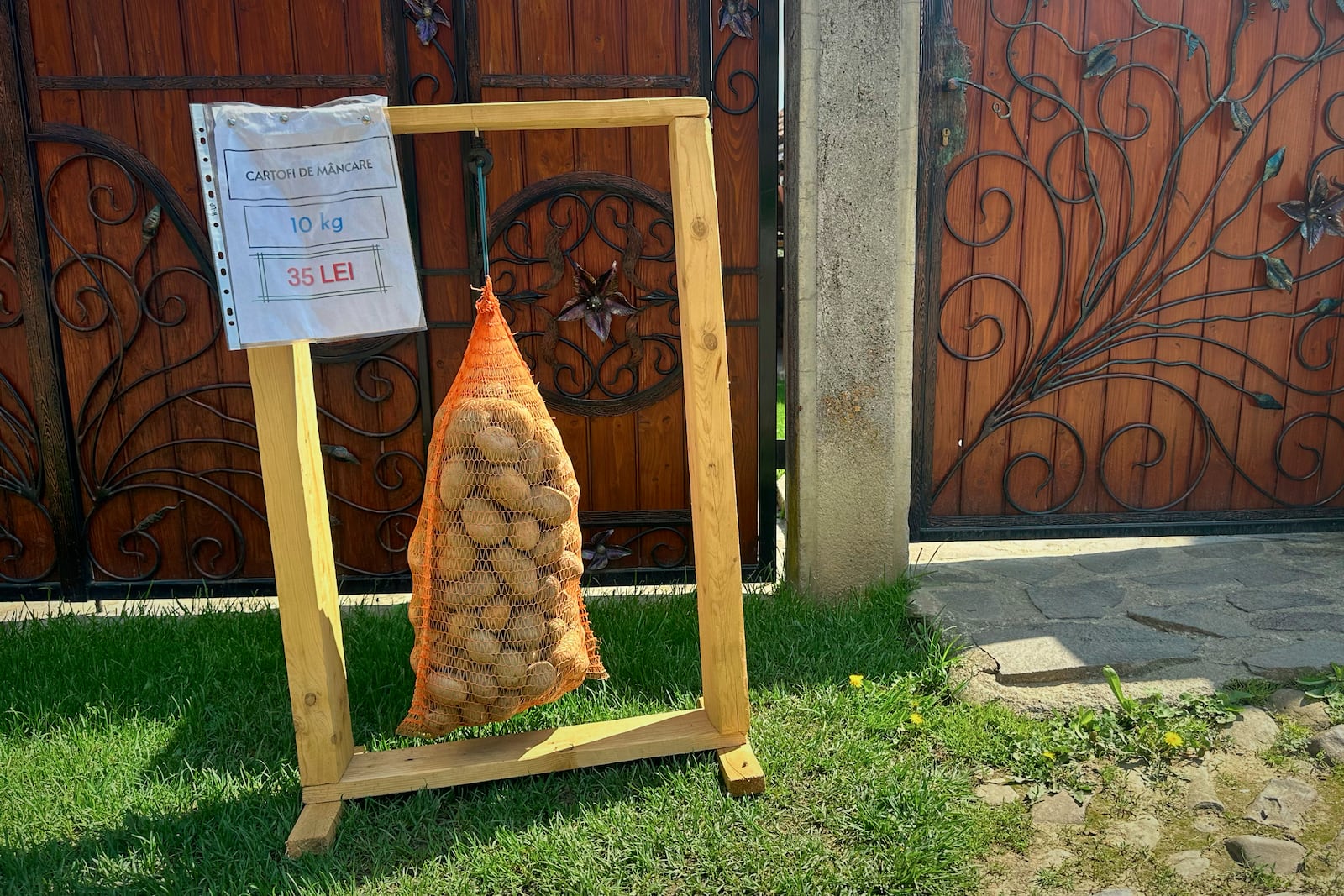 Potatoes on sale hang in a bag outside a house in the village of Saschiz, in Romania's central Transylvania region, Friday, April 25, 2025. (AP Photo/Stephen McGrath)