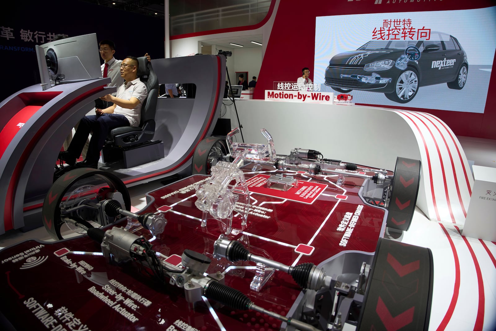 A visitor tries out a driving platform at the booth for auto parts manufacturer Nexteer Automotive during the Shanghai auto show on Thursday, April 24, 2025. (AP Photo/Ng Han Guan)