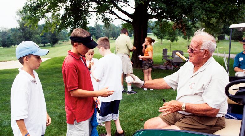 Joe Nuxhall autographs baseballs for West Chester residents, from left, Michael Wright and Brad McNulty, during the 2001 Joe Nuxhall Scholarship Golf Tournament at the Elks. FILE PHOTO