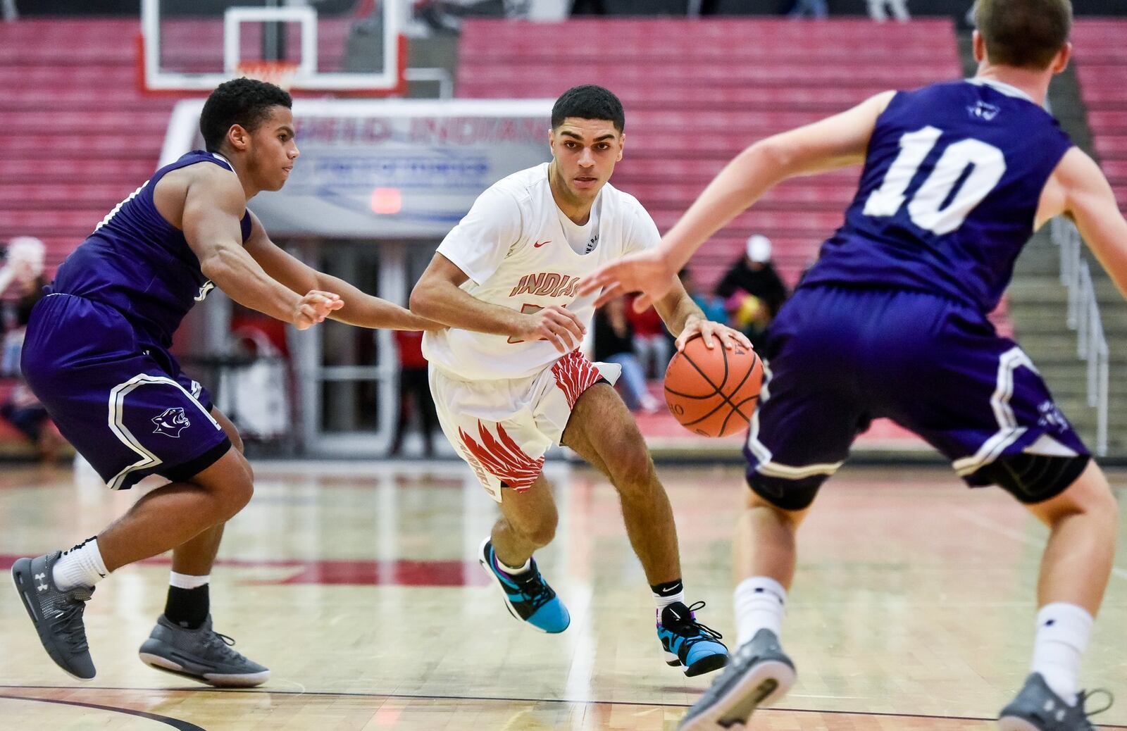 Fairfield’s Peyton Brown drives to the hoop between Elder’s Bryson Merz (left) and Matthew Luebbe on Friday night at the Fairfield Arena. Elder won 62-55. NICK GRAHAM/STAFF