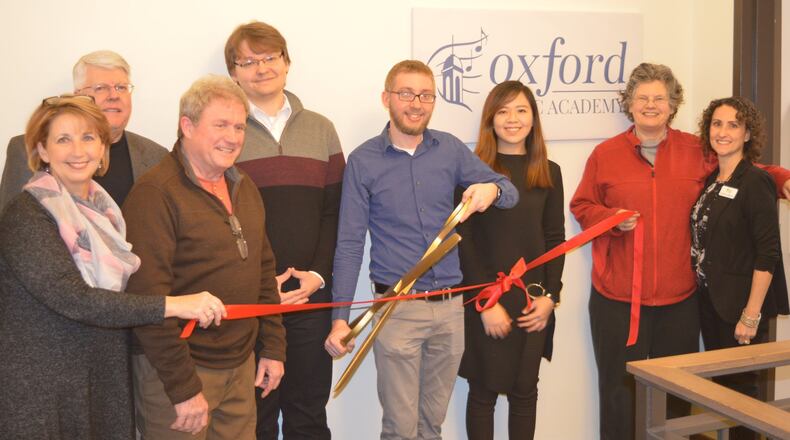 Jon Sanford holds the ceremonial Chamber of Commerce scissors at the ribbon-cutting officially opening his Oxford Music Academy Jan. 31. On hand for the occasion were city and chamber representatives. CONTRIBUTES/BOB RATTERMAN