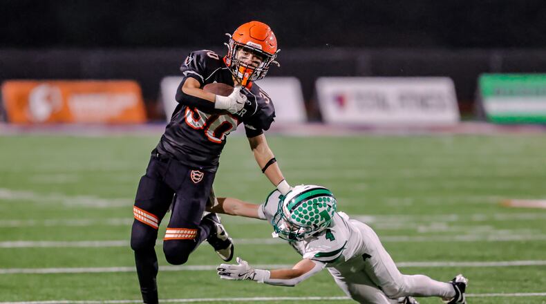 Coldwater High School sophomore John Pohlman runs past Anna's Zeb Pleiman during their game on Friday, Nov. 21, 2025, at Piqua's Alexander Stadium. The Cavaliers won 14-12 to win the Division VI, Region 24 final. MICHAEL COOPER / STAFF PHOTO