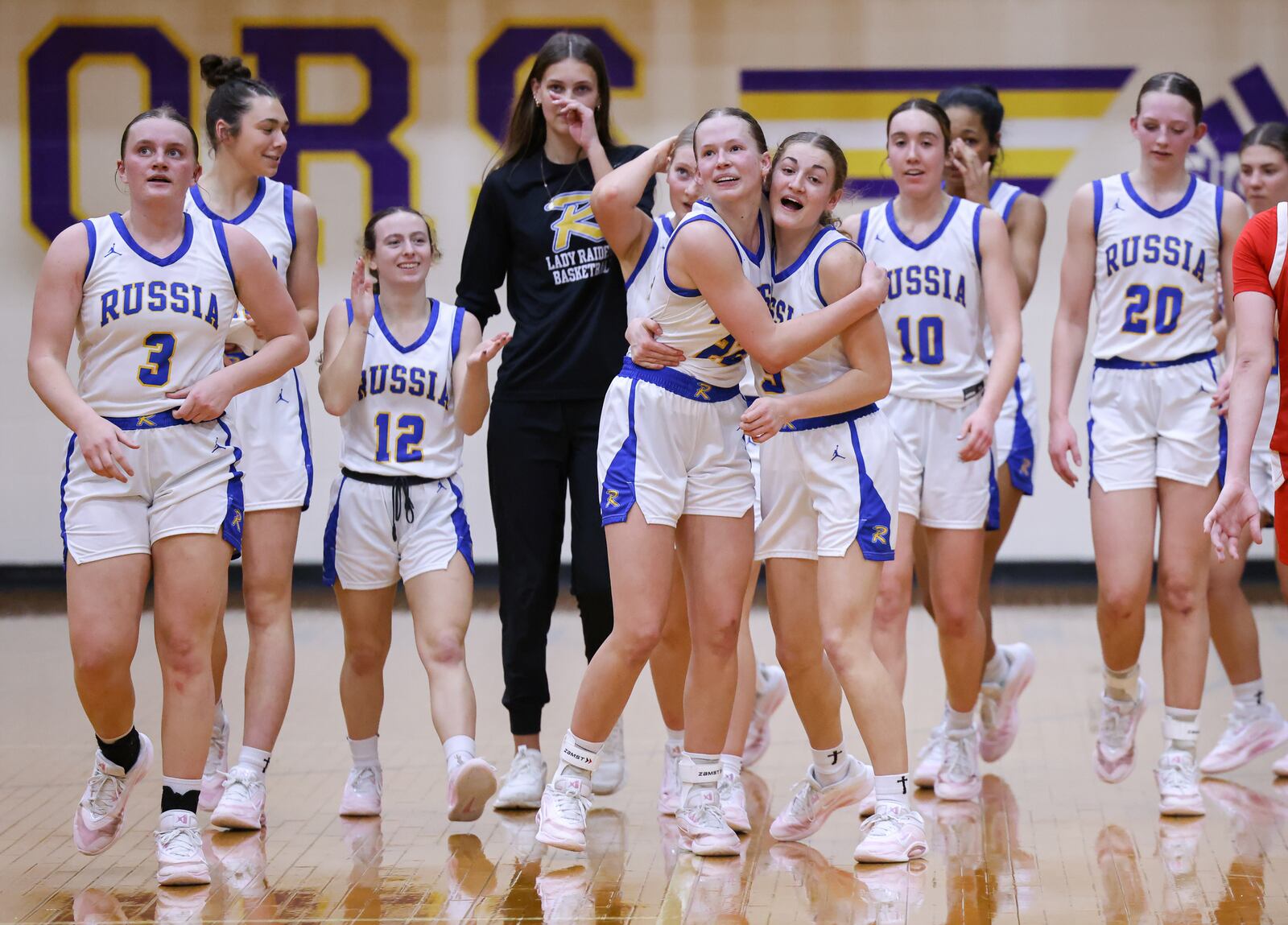 Russia junior forward Celeste Borchers (center left) celebrates with senior guard Callie Goubeaux (center right) after Russia beat Cedarville 40-32 in a Division VII regional final on Saturday, March 7 at Vandalia-Butler's Student Activity Center. BRYANT BILLING / STAFF