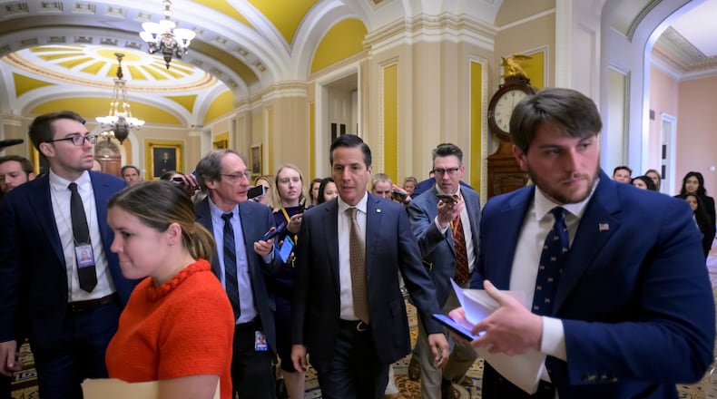 Sen. Bernie Moreno, R-Ohio, center, talks with reporters as he walks through the Ohio Clock Corridor at the Capitol, Tuesday, Jan. 13, 2026, in Washington. (AP Photo/Rod Lamkey, Jr.)