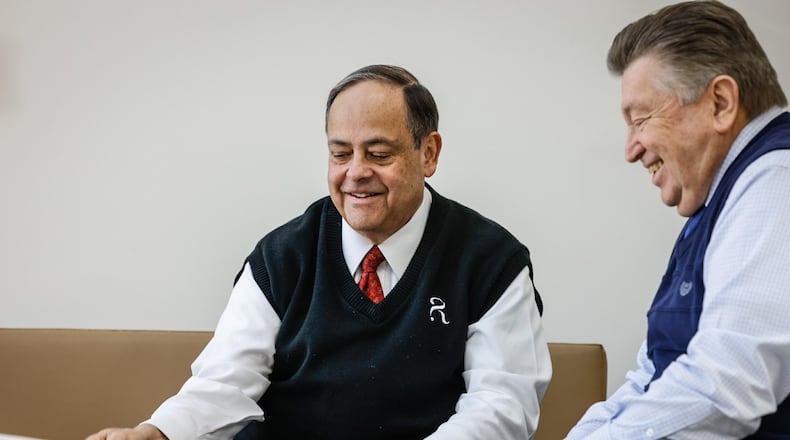 Rafi Rodriguez, left, president of Rodriguez Financial Strategies LLC in Beavercreek meets with his client, Randy Gallas, for regular retirement  checkups. JIM NOELKER/STAFF