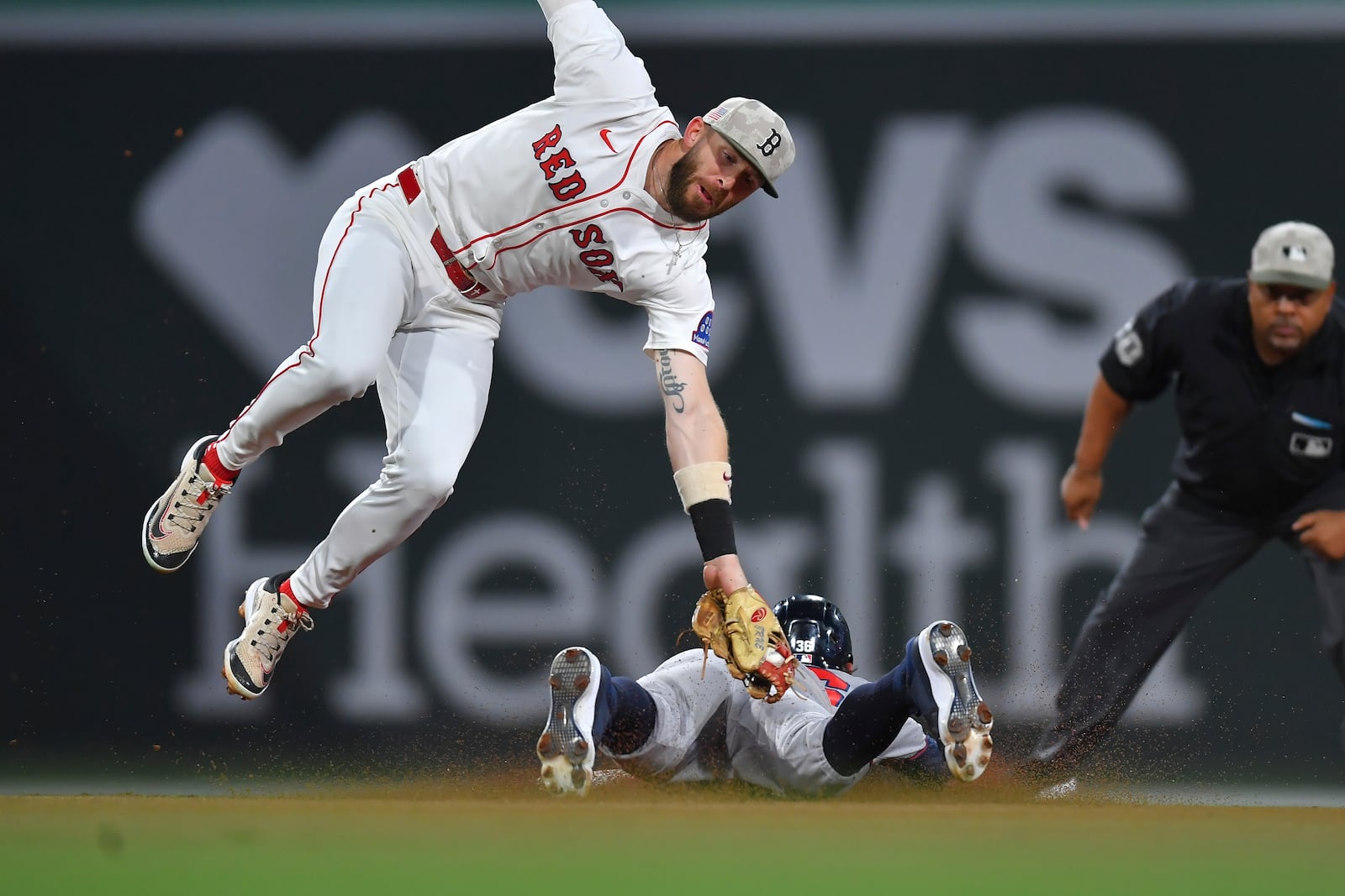 Boston Red Sox shortstop Trevor Story, top left, is unable to get his glove on Atlanta Braves' Eli White, bottom, as White steals second base in the fourth inning of a baseball game, Saturday, May 17, 2025, in Boston. (AP Photo/Steven Senne)