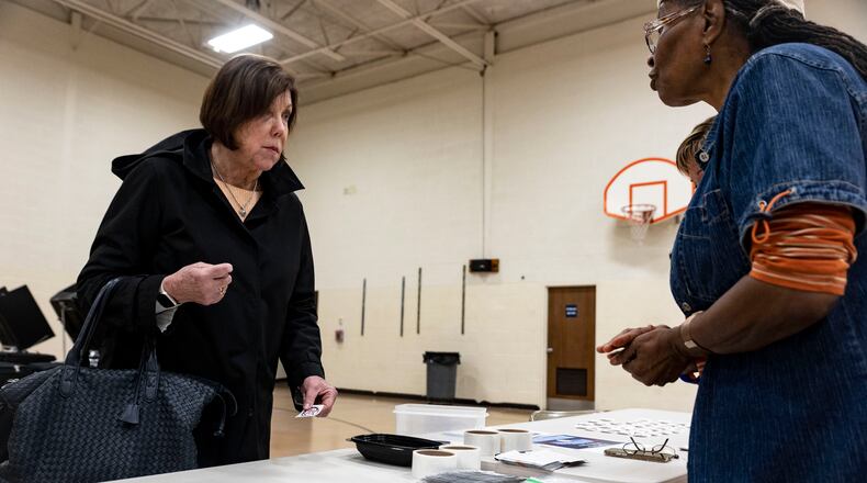 FILE - Marcia Carroll, 72, of Perrysburg takes an Ohio voting sticker at the Woodland Elementary School Polling location in Perrysburg, Ohio, on Tuesday May 3, 2022. The great vote-by-mail wave appears to be receding just as quickly as it arrived. After tens of millions of Americans opted for mail ballots during the pandemic election of 2020, voters in the early primary states are returning in droves to in-person voting. (Stephen Zenner/The Blade via AP, File)