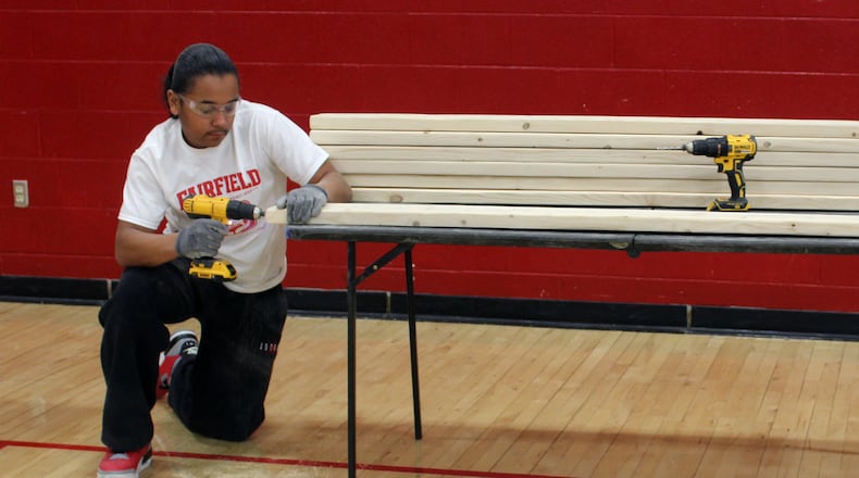 Sophomores Travon Steele and Issa Dumbuya drilled holes in what would become part of a frame for beds being built Tuesday by Fairfield High School students in cooperation with Sleep in Heavenly Peace. SUE KIESEWETTER/CONTRIBUTED