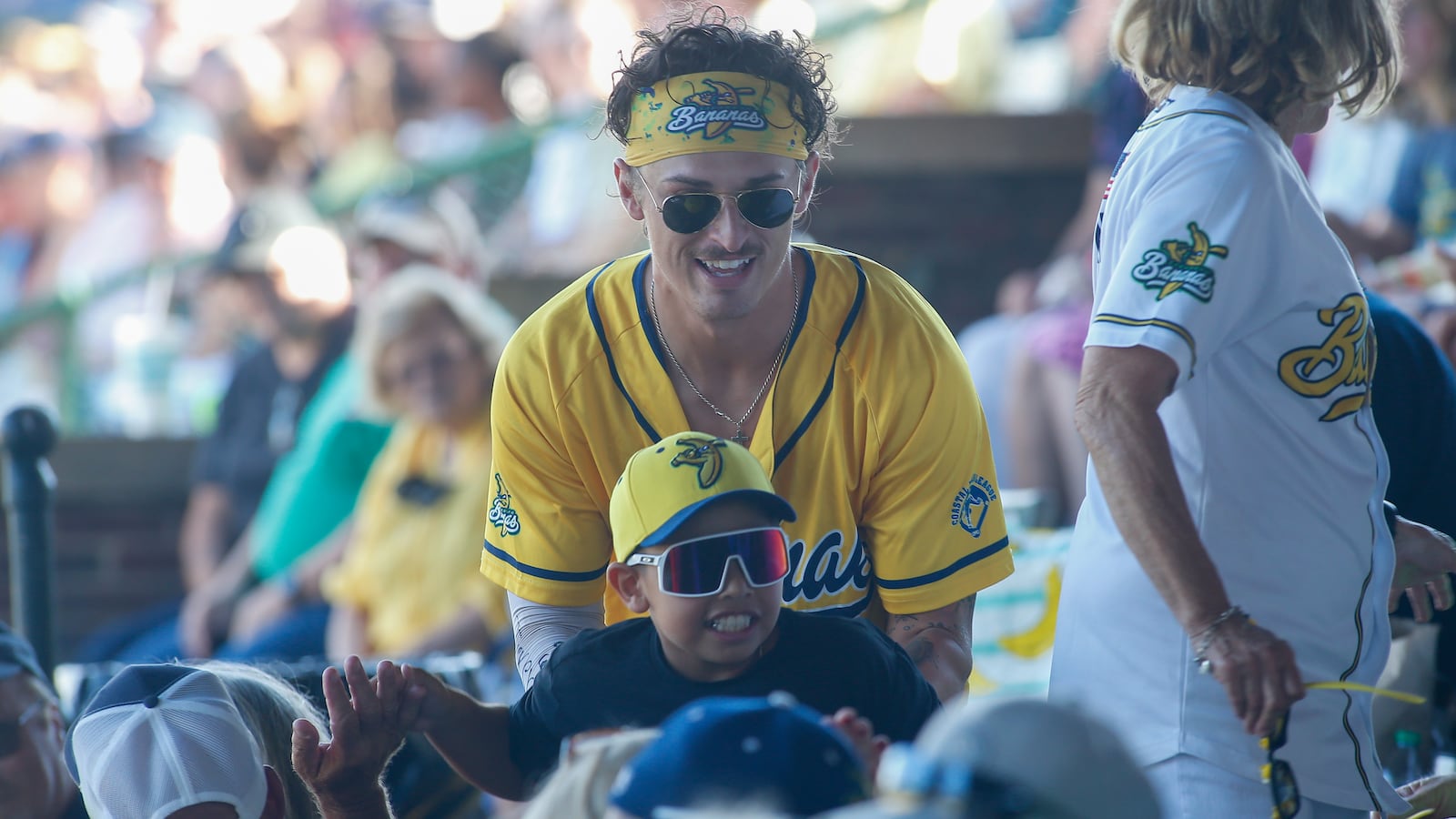 Northwestern High School grad Gage Voorhees participates in a race through the grandstands with a young fan on Saturday, June 25, 2022, at Grayson Stadium in Savannah, Ga. Photo by Michael Cooper