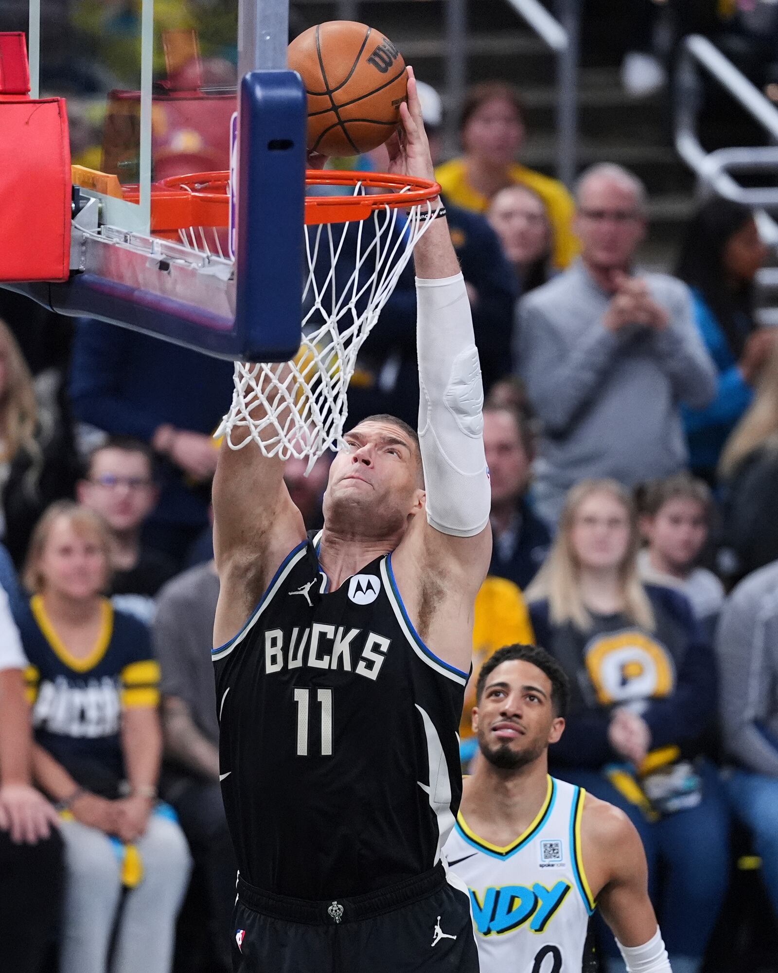Milwaukee Bucks center Brook Lopez (11) gets a dunk in front of Indiana Pacers guard Tyrese Haliburton (0) during the first half of a first-round NBA basketball playoff game in Indianapolis, Tuesday, April 22, 2025. (AP Photo/Michael Conroy)