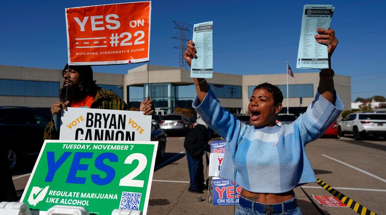 Nikko Griffin, left, and Tyra Patterson, call out to arriving voters in the parking lot of the Hamilton County Board of Elections during early in-person voting in Cincinnati, Thursday, Nov. 2, 2023. They urge people to vote for different issues, including Issue 2, which would allow adult-use sale, purchase, and possession of cannabis for Ohioans who are 21 and older. They also pass out Hamilton County Democratic Party sample ballots. Ohioans will decide next week on whether to legalize recreational marijuana, but people on both sides of the issue say more hangs in the balance than simply decriminalizing the drug. (AP Photo/Carolyn Kaster)