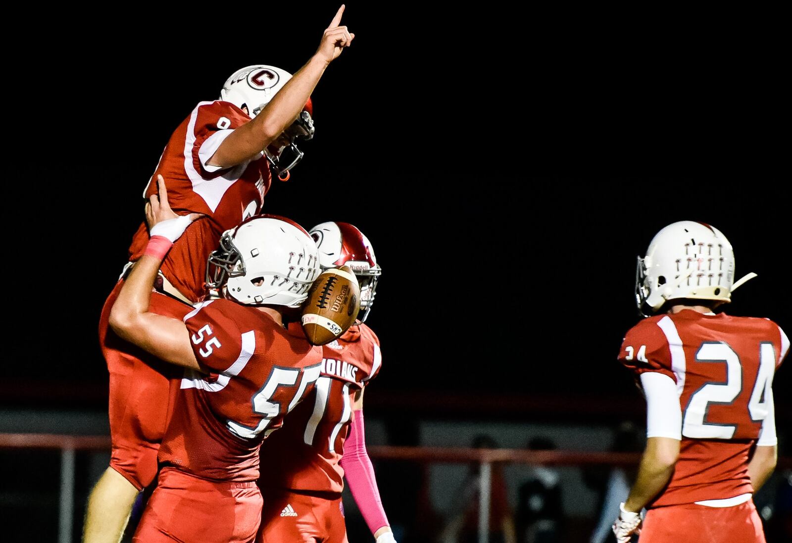 Carlisle quarterback Jake Moore is lifted up by teammate Braden O’Connor (55) after scoring a touchdown against Eaton on Thursday night at Laughlin Field in Carlisle. NICK GRAHAM/STAFF