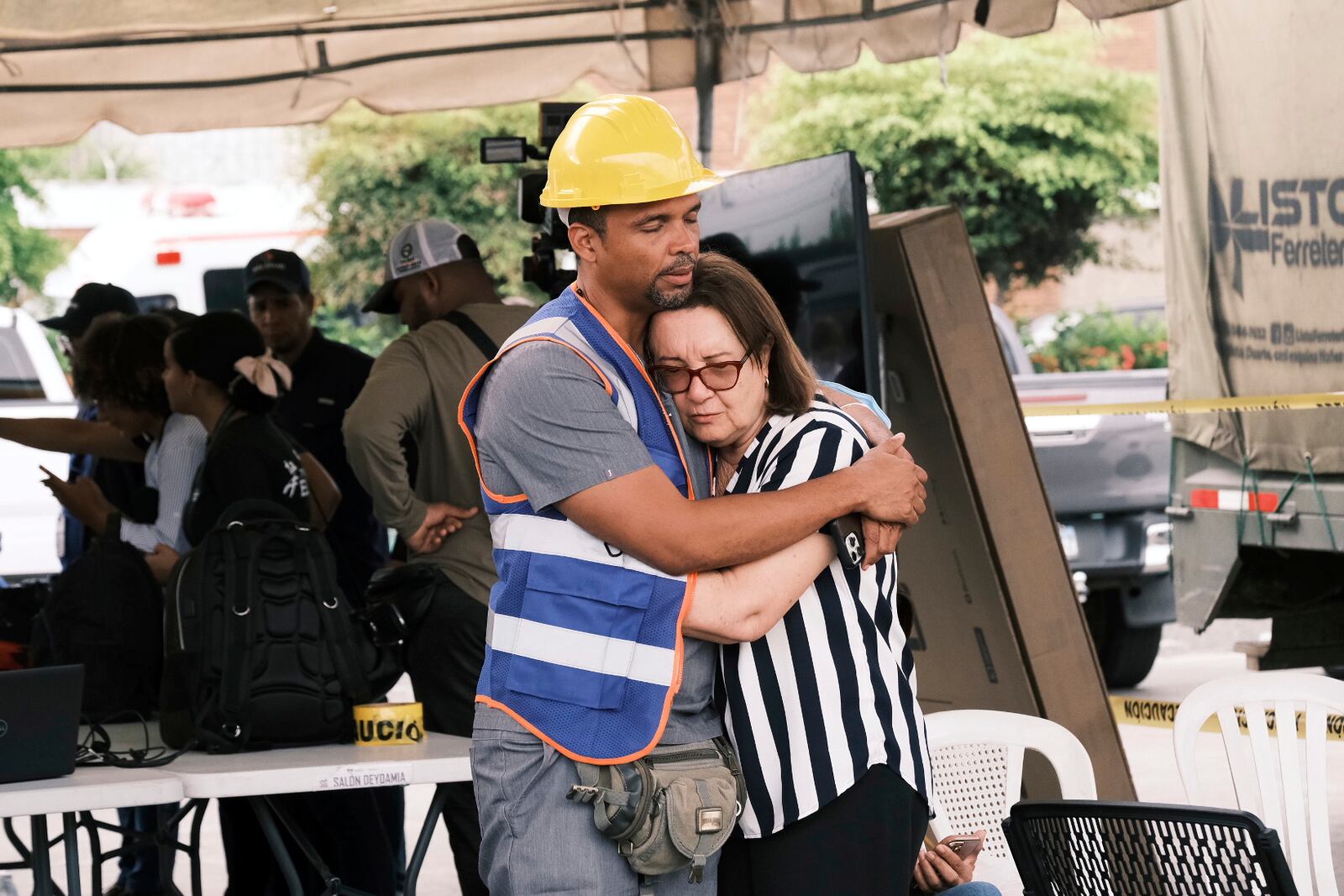 A rescue worker comforts a woman during the search for survivors at the Jet Set nightclub after its roof collapsed two nights prior during a merengue concert in Santo Domingo, Dominican Republic, Wednesday, April 9, 2025. (AP Photo/Ricardo Hernandez)