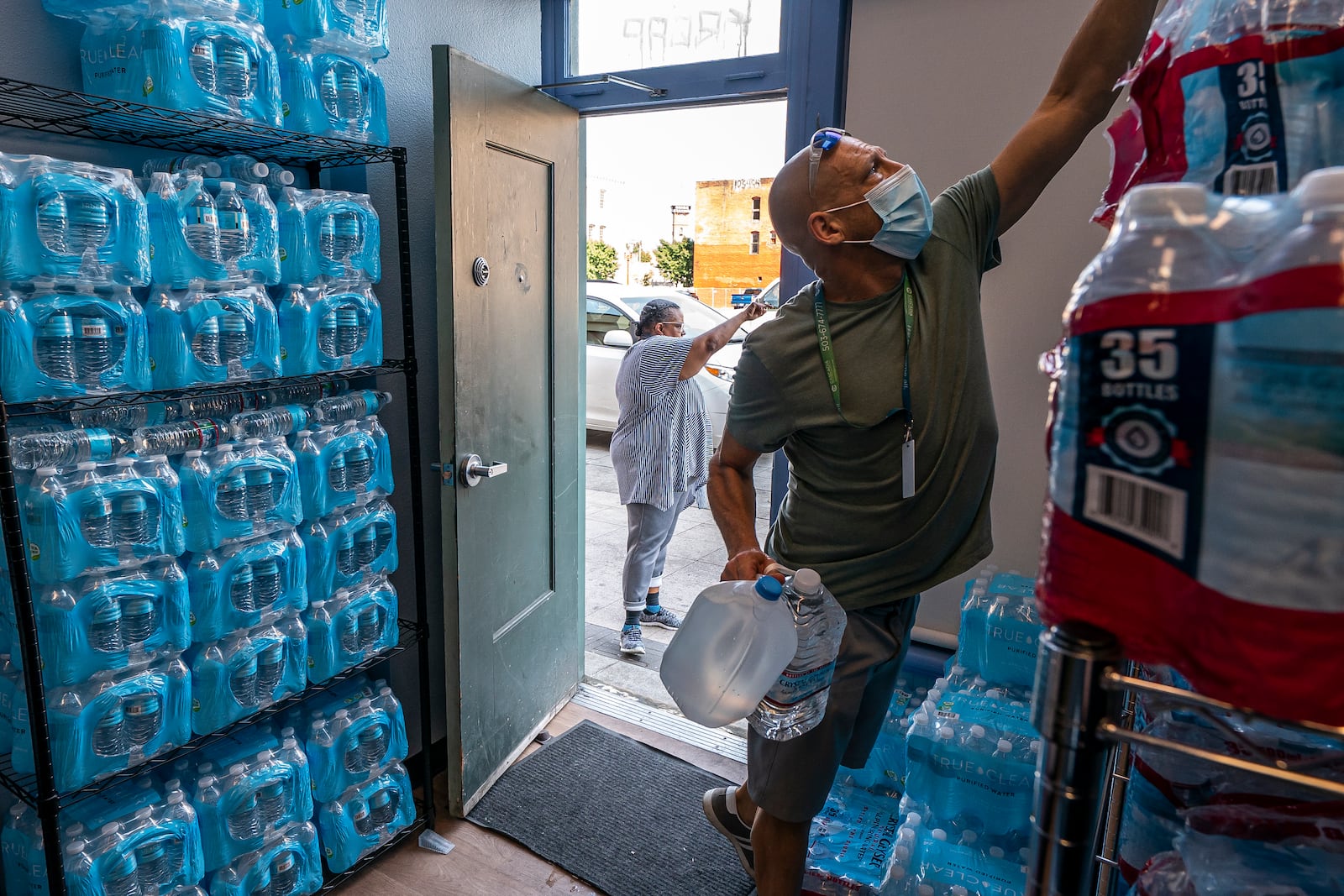 FILE - Chris Cowan, with Cascadia Behavioral Healthcare's street outreach team, loads water and other cooling supplies before visiting homeless camps on Aug. 12, 2021, in Portland, Ore. (AP Photo/Nathan Howard, File)