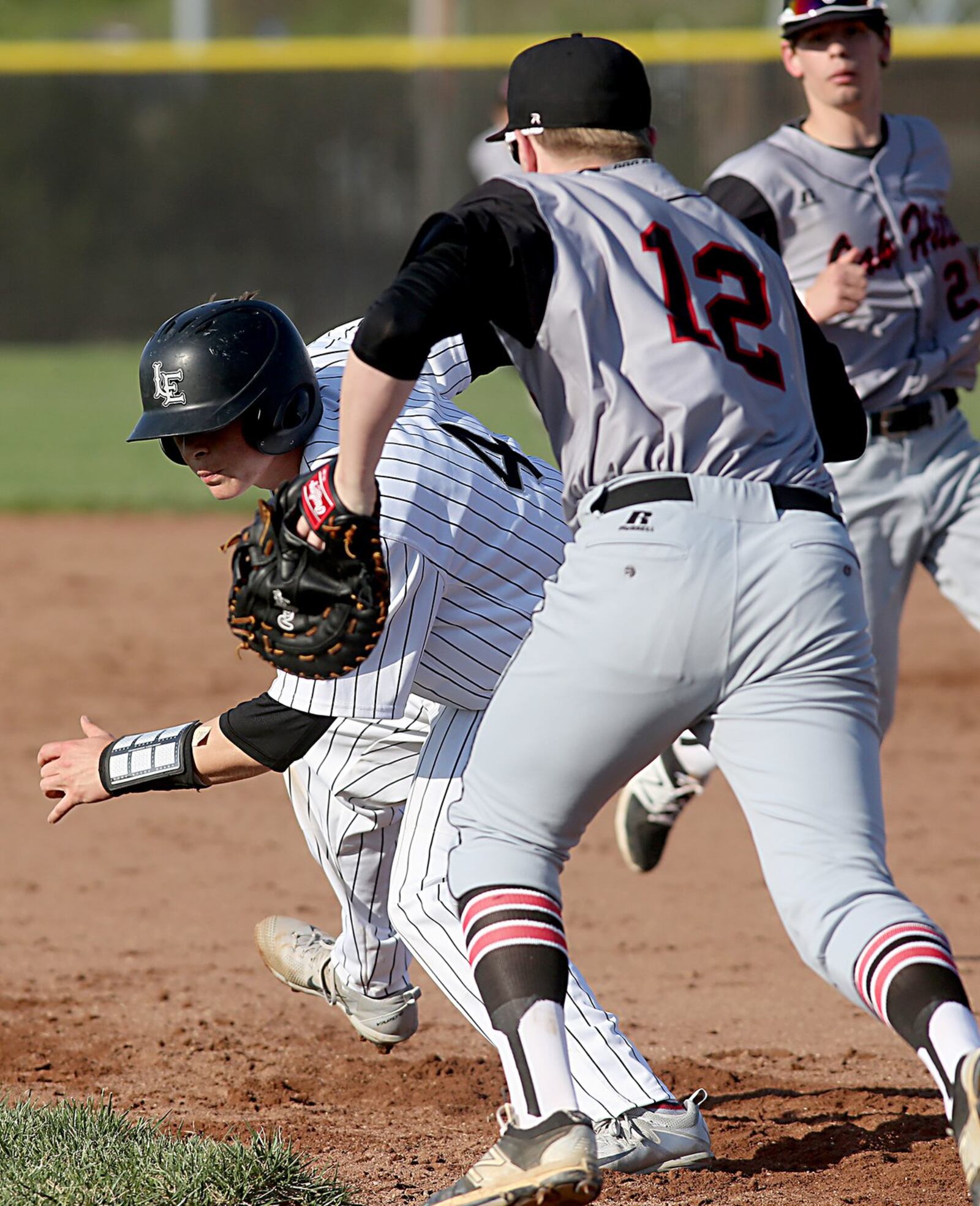 Lakota East’s Winston Owens gets caught off base and tagged out by Oak Hills first baseman Tyler Murphy during their game in Liberty Township on Tuesday. CONTRIBUTED PHOTO BY E.L. HUBBARD