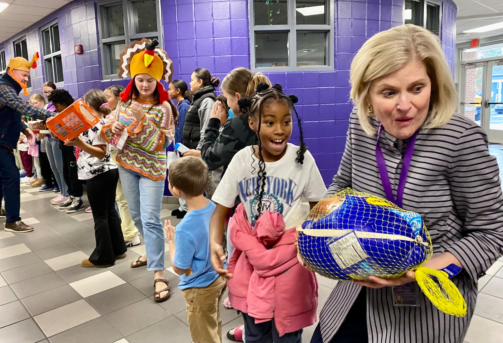 For more than a decade Middletown’s Central Elementary has made packing Thanksgiving meals and other items for needy local families a total school event.
The school’s annual “Turkey Pass” sees hundreds of the students line up in the school’s main hallway leading to the cafeteria and then each donated Thanksgiving food and care item is passed from one student’s hands to another. Joining students this year was Middletown Schools Superintendent Deborah Houser. (Photo By Michael D. Clark/Journal-News)