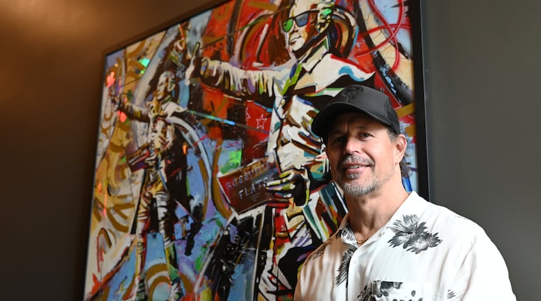 Kentucky-based artist Shawn Voelker created five unique pieces of artwork for the lobby of Rossville Flats which opened near the end of 2023 on Main Street in Hamilton. Pictured is Voelker in front of the piece inspired by The American Cape, the statue of Alexander Hamilton on High Street. MICHAEL D. PITMAN/STAFF
