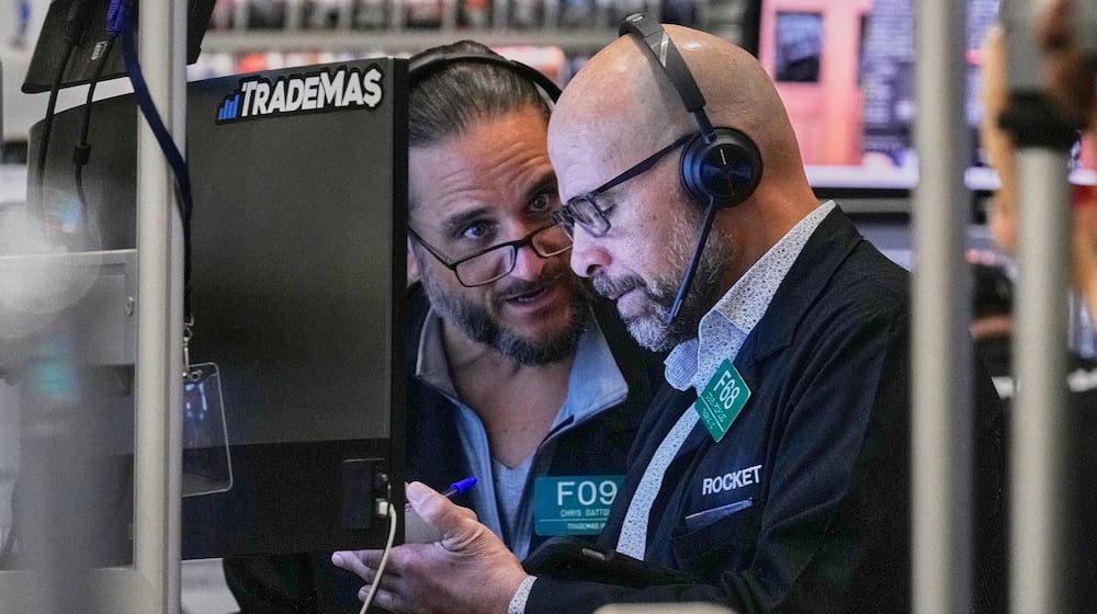 Options traders Chris Dattolo, left, and Steven Rodriguez work on the floor of the New York Stock Exchange, Friday, Feb. 20, 2026. (AP Photo/Richard Drew)