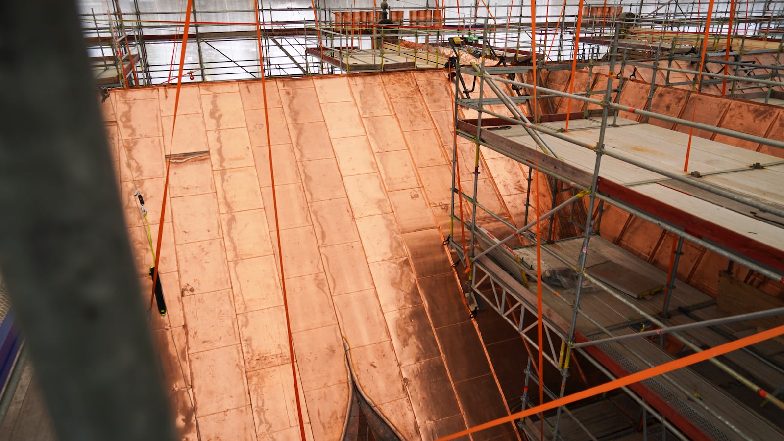 Section of the roof of the fire-damaged Old Stock Exchange building is covered with new coppersmiths in Copenhagen, Denmark, Monday, June 23, 2025. (AP Photo/James Brooks)
