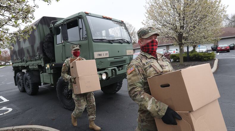 Ohio Army National Guardsmen, Sgt Kyle Smith, left, and Spc Logan Wilson deliver boxes of food to elderly residents in New Carlisle. BILL LACKEY/STAFF