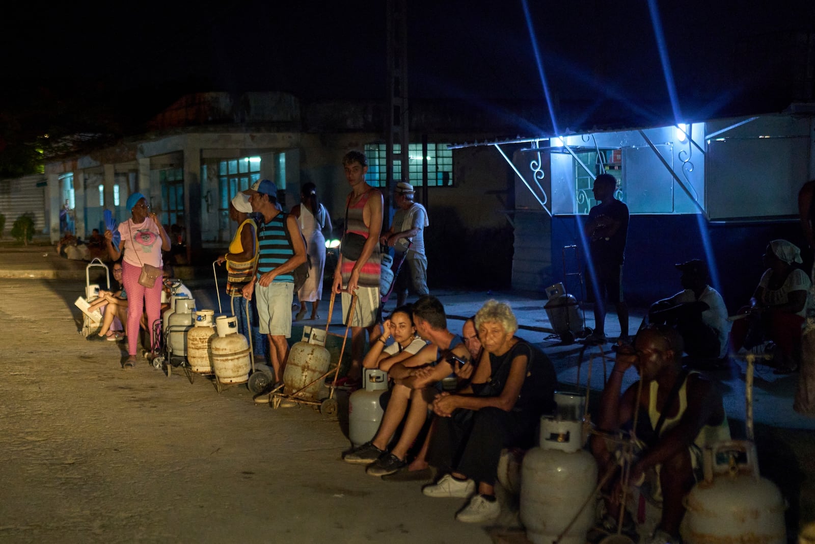 People wait to refill their cooking gas canisters in Alamar, Havana province, Cuba, late Saturday, May 31, 2025. (AP Photo/Ramon Espinosa)