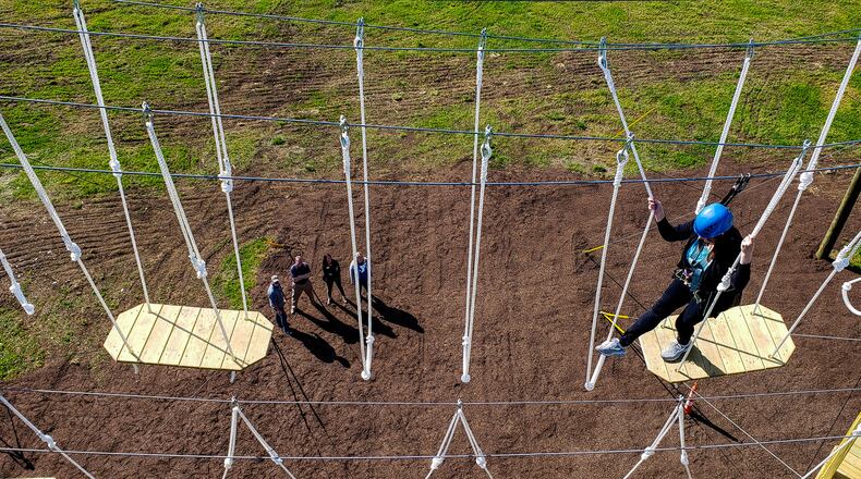 Patricia Dawson, public relations coordinator for Butler County Board of Developmental Disabilities, climbs on the Great Miami Valley YMCA's high ropes course now open at Camp Campbell Gard Wednesday, May 15, 2019 on Augspurger Road in St. Clair Township. The course stands nearly fifty feet tall with three levels of elements ranging in difficulty. There is also a climbing wall, zip line, giant swing and more. The course has a universal access system allowing participants with all abilities, including those in wheel chairs, the opportunity to experience it. NICK GRAHAM/STAFF