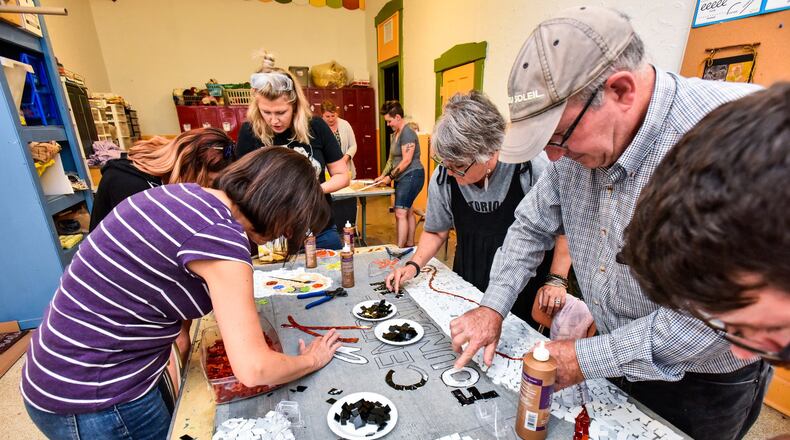 FLE: Art Central Foundation board members and instructors work on a mosaic mural July 26 in Middletown that features the Art Central Foundation logo. NICK GRAHAM/FILE