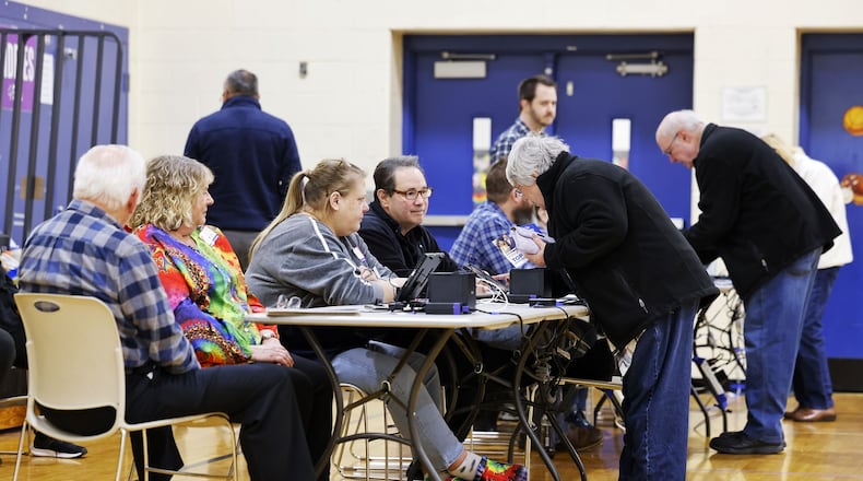 Poll workers check in voters on election day Tuesday, March 19, 2024 at Creekview Elementary School in Middletown. NICK GRAHAM/STAFF