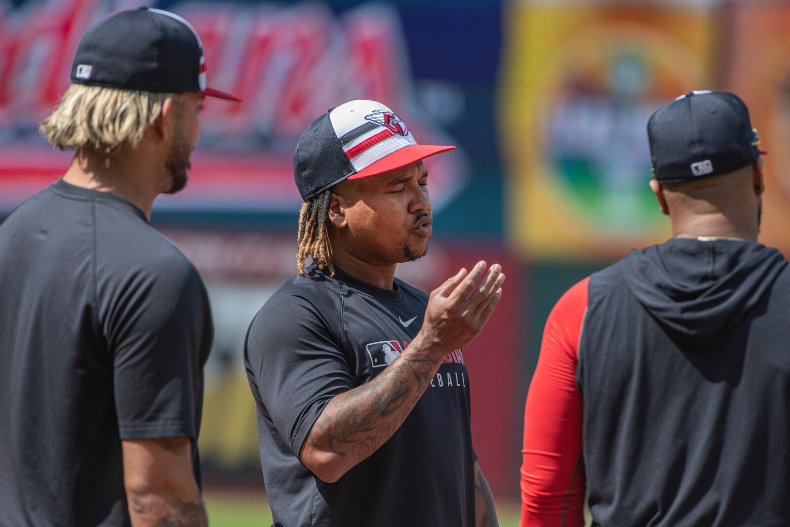 Cleveland Guardians' Jose Ramirez, center, talks with Gabriel Arias, left, and Carlos Santana, right, before a baseball game against the Cincinnati Reds, Tuesday June 10, 2025, in Cleveland. (AP Photo/Phil Long)