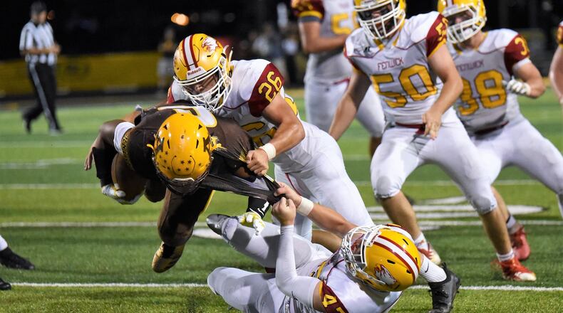 Fenwick’s Ben Gustely (47) and Logan Miller (26) tackle Alter’s Lamar Landers (6) during Friday night’s game at Centerville Stadium. Landers’ Knights won 45-20. CONTRIBUTED PHOTO BY ANGIE MOHRHAUS